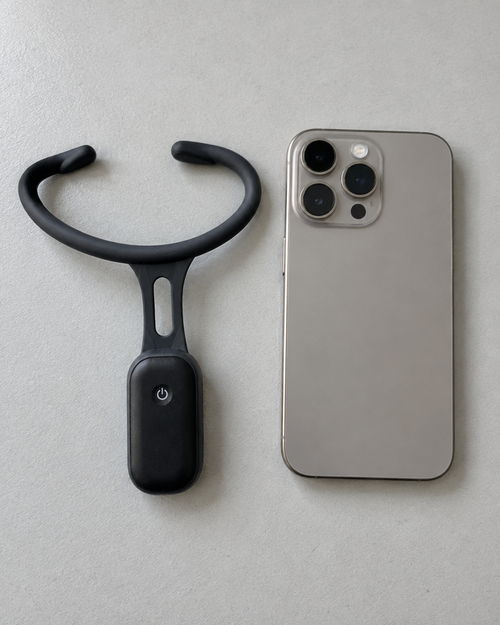 The Smart Posture Trainer shown beside a smartphone for size, about as wide as a phone is tall